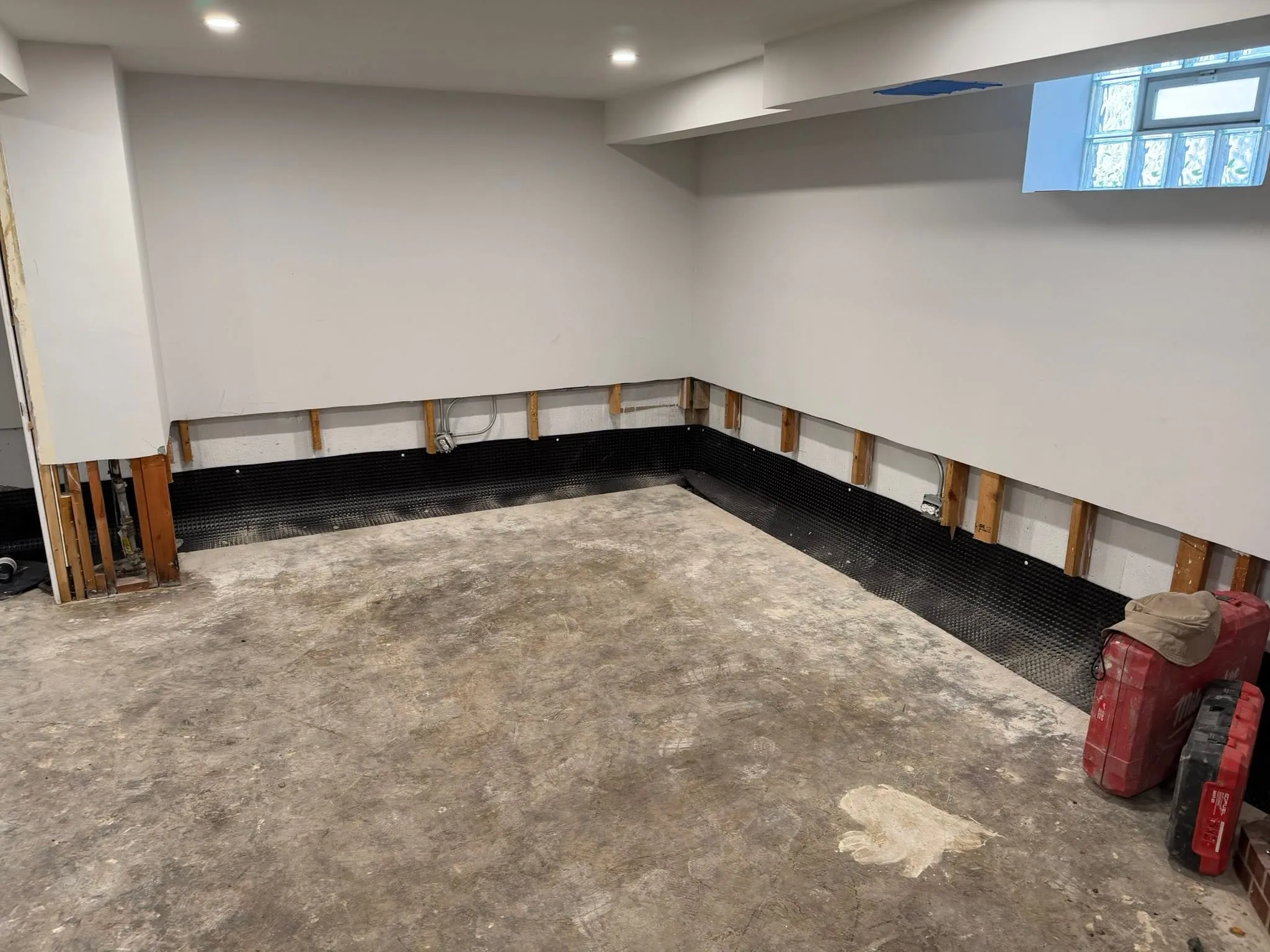 Interior basement perimeter with drainage membrane installed along the foundation wall
